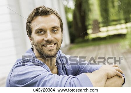 Close up portrait of mid adult man sitting on porch View Large Photo Image Picture - Close up portrait of mid adult man sitting on porch. Fotosearch