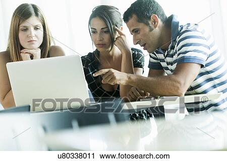 Colleagues having discussion using laptop View Large Photo Image Stock Image - Colleagues having discussion using laptop. Fotosearch