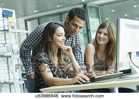 Colleagues having discussion using laptop View Large Photo Image Stock Photograph - Colleagues having discussion using laptop. Fotosearch