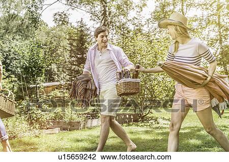 Couple walking in garden preparing for picnic View Large Photo Image Stock Image - Couple walking in garden preparing for picnic. Fotosearch