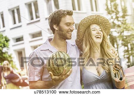 Stock Image - Couple with watermelon laughing. Fotosearch