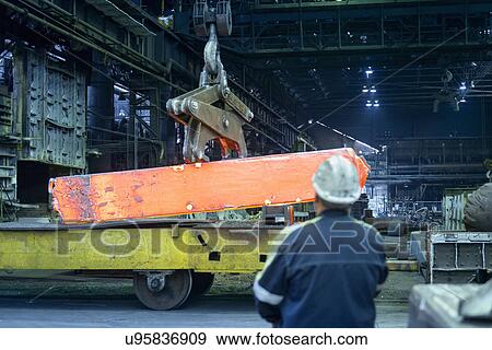 Stock Photo - Crane operator with red hot steel in furnace of steelworks. Fotosearch