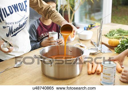 Cropped shot of boy pouring tin of tomato soup into saucepan View Large Photo Image Stock Photography - Cropped shot of boy pouring tin of tomato soup into saucepan. Fotosearch