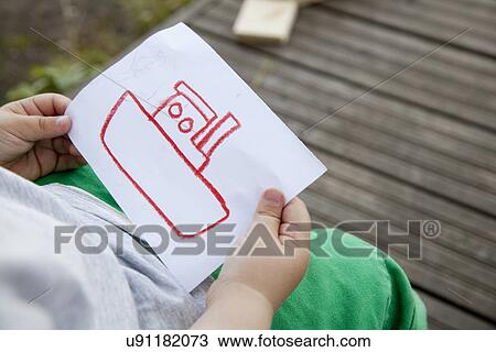 Cropped shot of male toddler holding drawing of a boat View Large Photo Image Stock Image - Cropped shot of male toddler holding drawing of a boat. Fotosearch
