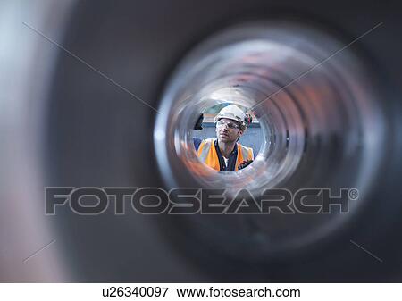 Stock Photo - Engineer checking steel part in engineering factory. Fotosearch
