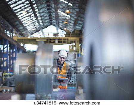 Engineer checking steel part in engineering factory View Large Photo Image Stock Photo - Engineer checking steel part in engineering factory. Fotosearch