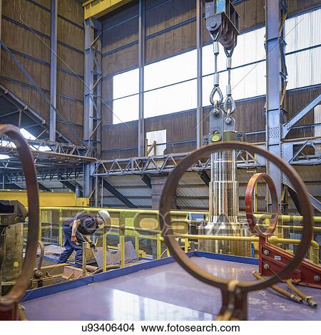 Picture - Engineer heat treating steel parts in engineering factory. Fotosearch