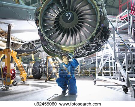 Engineer inspecting jet engine in aircraft maintenance factory View Large Photo Image Stock Image - Engineer inspecting jet engine in aircraft maintenance factory. Fotosearch