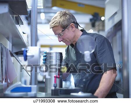 Engineer inspecting part at work station in engineering factory View Large Photo Image Stock Photo - Engineer inspecting part at work station in engineering factory. Fotosearch