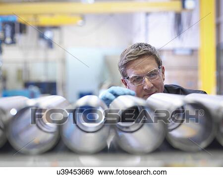 Engineer inspecting steel parts in factory View Large Photo Image Stock Photo - Engineer inspecting steel parts in factory. Fotosearch