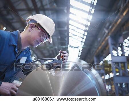 Engineer measuring steel part in engineering factory View Large Photo Image Stock Photo - Engineer measuring steel part in engineering factory. Fotosearch