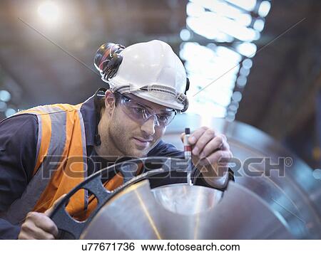 Stock Photograph - Engineer measuring steel part in engineering factory. Fotosearch