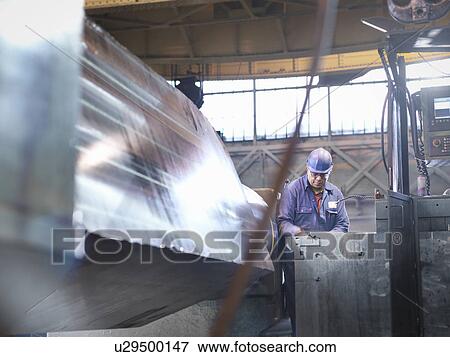 Engineer setting up specialist lathe in steel engineering factory View Large Photo Image Stock Photo - Engineer setting up specialist lathe in steel engineering factory. Fotosearch