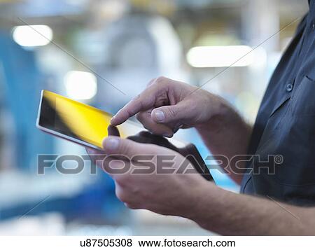 "Engineer using digital tablet in factory, close up" View Large Photo Image Stock Photo - "Engineer using digital tablet in factory, close up". Fotosearch