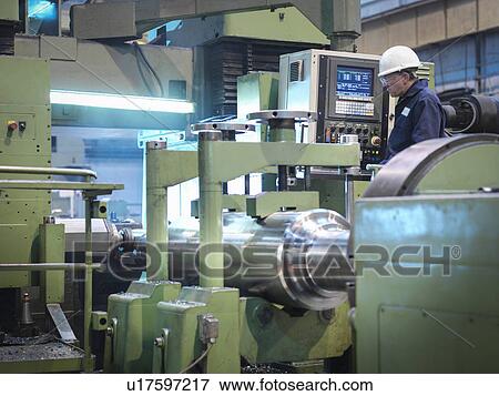Engineer working at lathe in engineering factory View Large Photo Image Stock Photo - Engineer working at lathe in engineering factory. Fotosearch