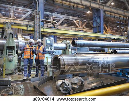 Engineers checking steel tubes in engineering factory View Large Photo Image Picture - Engineers checking steel tubes in engineering factory. Fotosearch