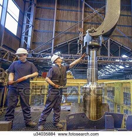 Picture - Engineers heat treating steel parts in engineering factory. Fotosearch