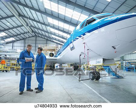 Engineers in discussion by aircraft in aircraft maintenance factory View Large Photo Image Stock Image - Engineers in discussion by aircraft in aircraft maintenance factory. Fotosearch