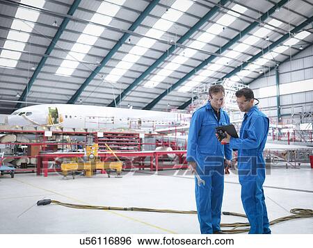 Engineers in discussion in aircraft maintenance factory View Large Photo Image Stock Photograph - Engineers in discussion in aircraft maintenance factory. Fotosearch