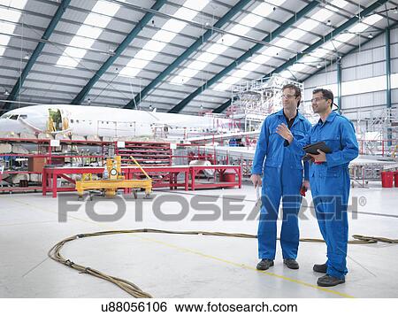 Engineers in discussion in aircraft maintenance factory View Large Photo Image Stock Photograph - Engineers in discussion in aircraft maintenance factory. Fotosearch