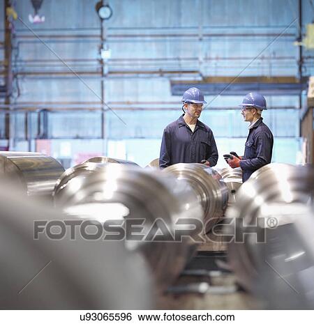 Stock Photograph - Engineers in discussion in engineering factory. Fotosearch