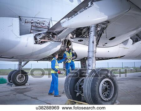 Engineers recycling aircraft parts from airplane on runway View Large Photo Image Stock Photo - Engineers recycling aircraft parts from airplane on runway. Fotosearch