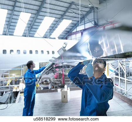 Engineers working on aircraft wing in aircraft maintenance factory View Large Photo Image Stock Photo - Engineers working on aircraft wing in aircraft maintenance factory. Fotosearch