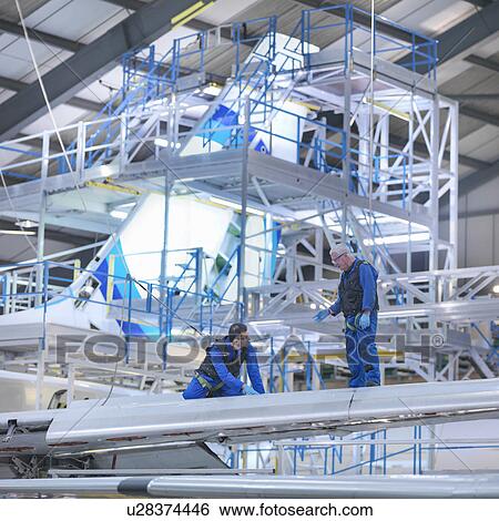 Engineers working on aircraft wing in aircraft maintenance factory View Large Photo Image Stock Photograph - Engineers working on aircraft wing in aircraft maintenance factory. Fotosearch