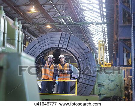 Stock Photo - Engineers working together in engineering factory. Fotosearch