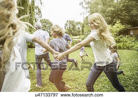Family running in garden View Large Photo Image Stock Photo - Family running in garden. Fotosearch