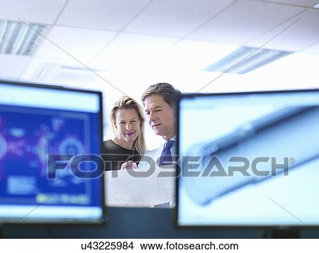 Picture - Female and male engineer designers discussing plans in office. Fotosearch