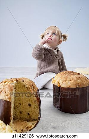 Female toddler sitting on floor with pannetone cakes View Large Photo Image Stock Photograph - Female toddler sitting on floor with pannetone cakes. Fotosearch