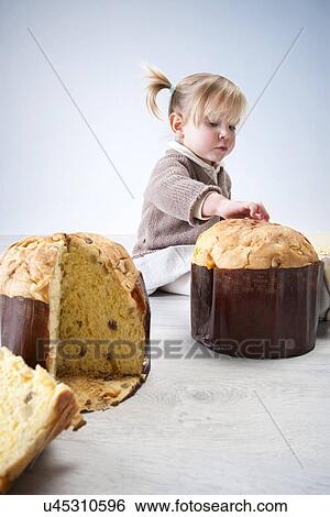 Female toddler sitting on floor with fingers on pannetone cake View Large Photo Image Stock Photograph - Female toddler sitting on floor with fingers on pannetone cake. Fotosearch
