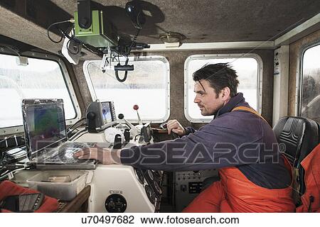 Fisherman driving fishing boat using laptop View Large Photo Image Stock Image - Fisherman driving fishing boat using laptop. Fotosearch