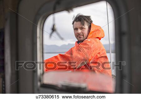 Stock Photography - Fisherman seen through fishing boat window. Fotosearch