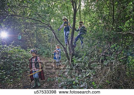Stock Photo - Four boys dressed up and playing in forest trees. Fotosearch