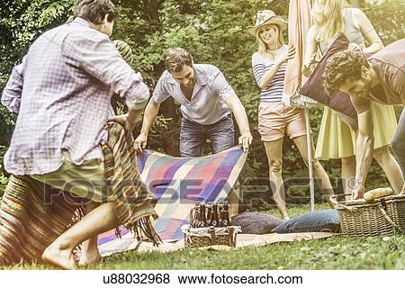 Friend preparing for picnic in garden View Large Photo Image Stock Photo - Friend preparing for picnic in garden. Fotosearch