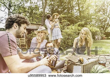 Stock Image - Friends drinking beer in garden. Fotosearch