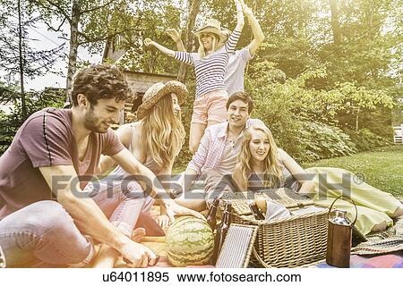 Stock Photography - Friends having picnic in garden. Fotosearch