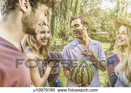 Friends in garden holding watermelon View Large Photo Image Stock Photography - Friends in garden holding watermelon. Fotosearch