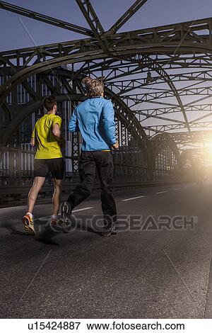 "Friends jogging on bridge, Munich, Bavaria, Germany" View Large Photo Image Stock Photo - "Friends jogging on bridge, Munich, Bavaria, Germany". Fotosearch