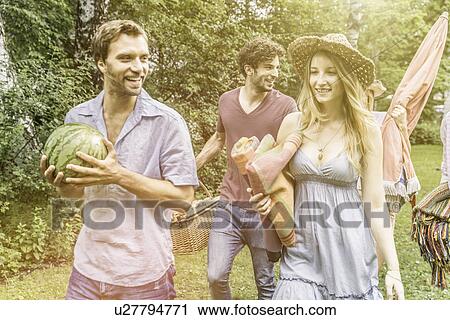 Friends preparing for picnic in garden View Large Photo Image Stock Image - Friends preparing for picnic in garden. Fotosearch