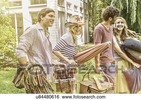 Friends preparing for picnic in garden View Large Photo Image Stock Photograph - Friends preparing for picnic in garden. Fotosearch