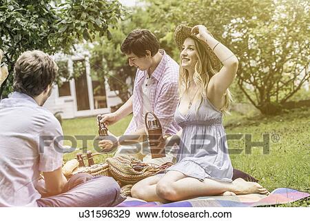 Friends sitting having picnic in garden View Large Photo Image Stock Photo - Friends sitting having picnic in garden. Fotosearch