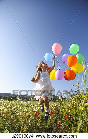 "Girl jumping for joy with colorful balloons in wildflower meadow, Majorca, Spain" View Large Photo Image Picture - "Girl jumping for joy with colorful balloons in wildflower meadow, Majorca, Spain". Fotosearch