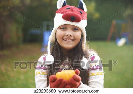 Girl with pumpkin posing in garden View Large Photo Image Stock Image - Girl with pumpkin posing in garden. Fotosearch