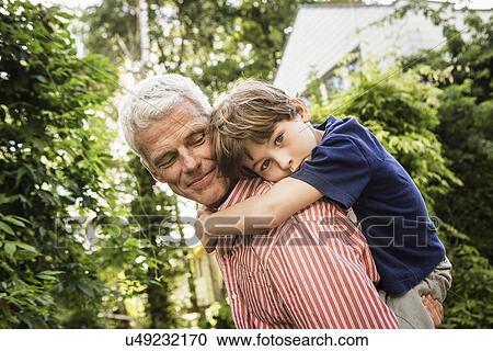 Grandfather carrying grandson on back View Large Photo Image Stock Image - Grandfather carrying grandson on back. Fotosearch