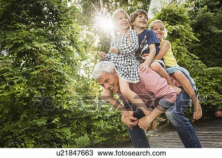 Grandfather carrying three grandchildren on back View Large Photo Image Stock Image - Grandfather carrying three grandchildren on back. Fotosearch