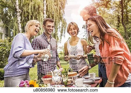 Group of friends enjoying garden party View Large Photo Image Stock Image - Group of friends enjoying garden party. Fotosearch