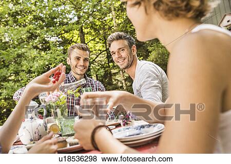 Stock Photo - Group of friends enjoying garden party. Fotosearch
